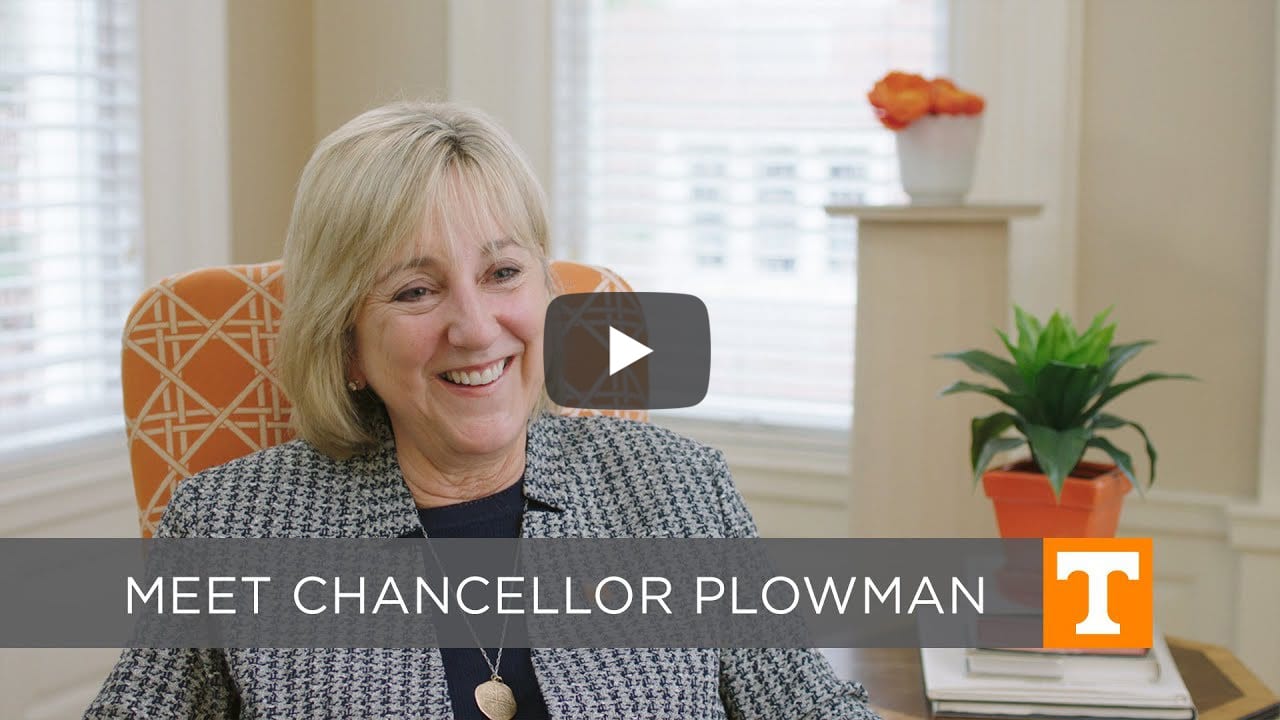 Video still of Chancellor Plowman in an orange chair, smiling.
