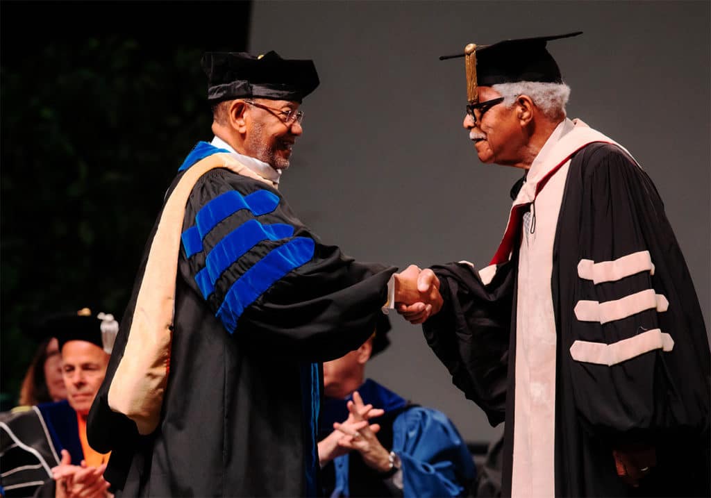 Theotis Robinson Jr. shaking hands during the honorary degree ceremony.