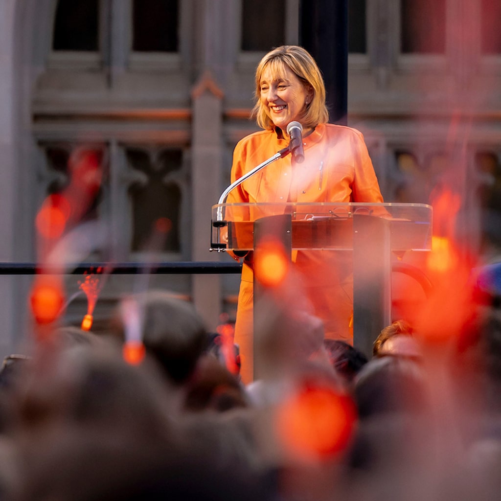 Donde Plowman at a podium talking in front of a crowd